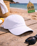 White perforated breathable baseball cap on wooden surface at beach