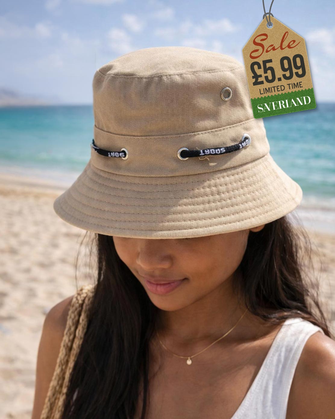 Beige cotton sport bucket hat shown upright and interior view on sand at beach