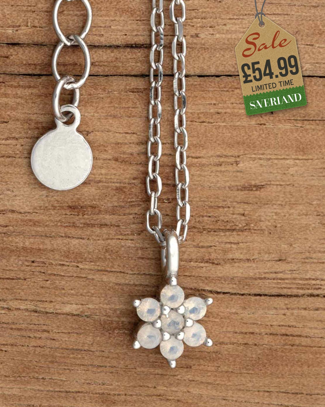 Silver chain necklace with opalescent crystal flower cluster pendant on wooden background