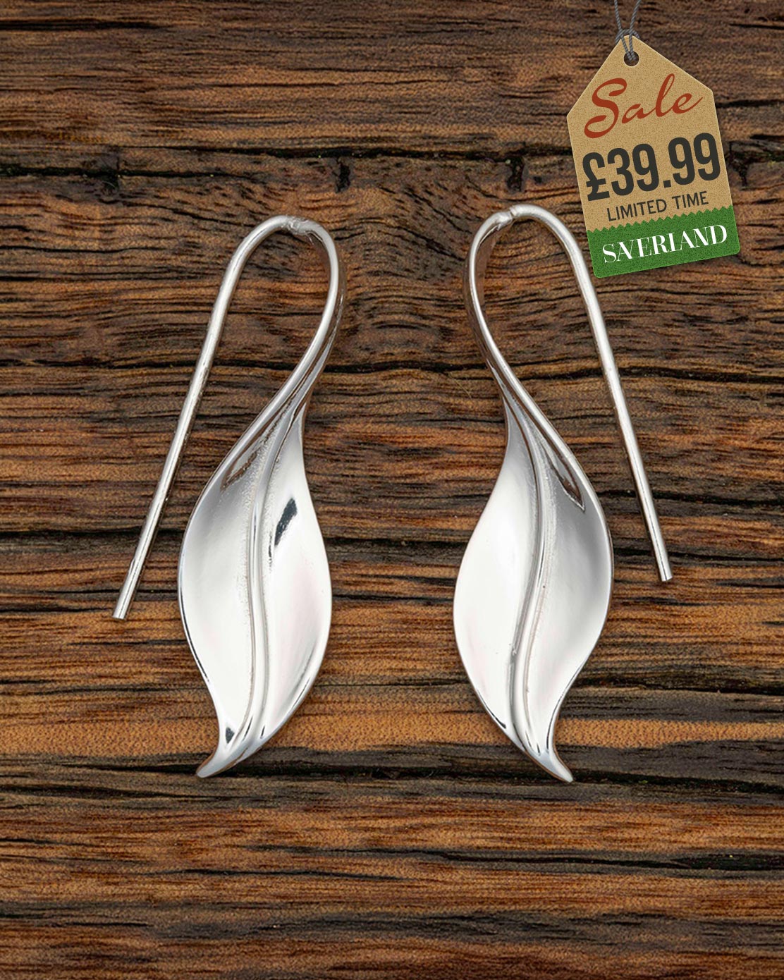 Polished silver leaf-shaped drop earrings with shepherd hook wires on a wooden background