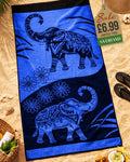 Royal Blue and black mandala elephant jacquard beach towel laid flat on sand with beach accessories