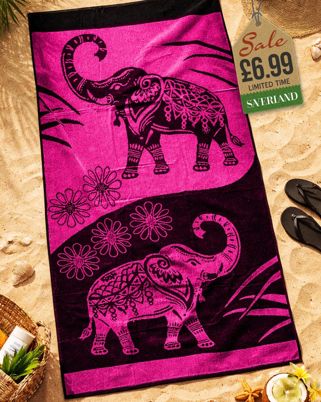 Hot Pink and black mandala elephant jacquard beach towel laid flat on sand with beach accessories