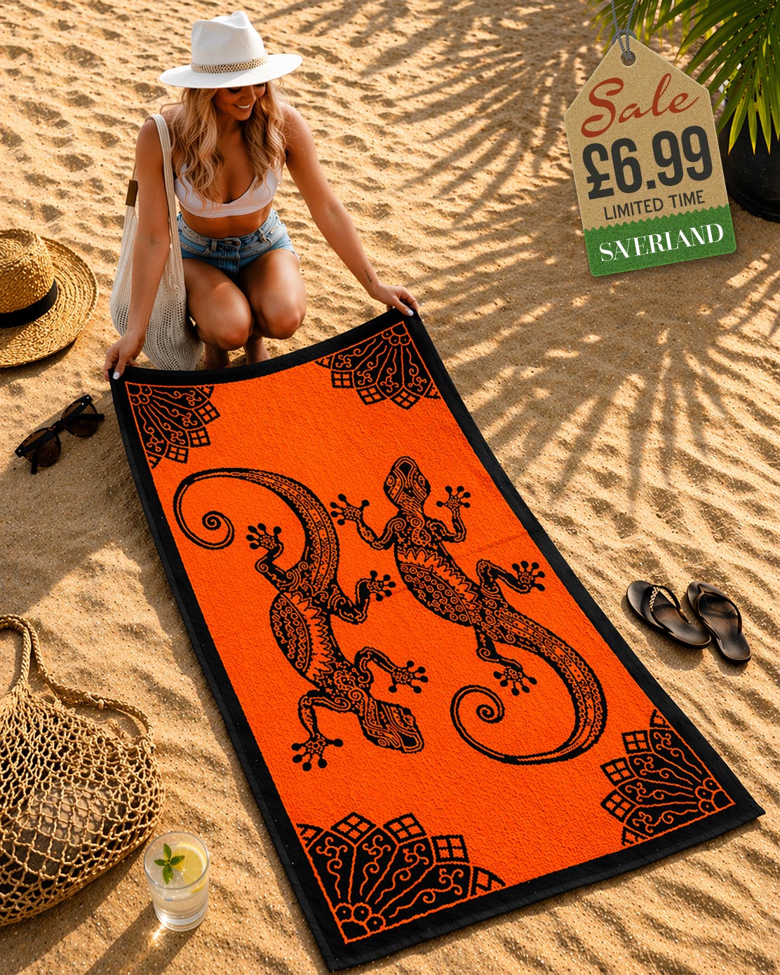 Woman laying out a orange and black tribal gecko beach towel on sand at beach