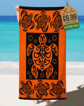 Orange and black tribal Polynesian sea turtle beach towel held up at the beach