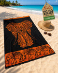 Burnt Orange tribal elephant head beach towel laid on sand at tropical beach