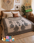 Black and white dream catcher print bed throw draped over a boho-style bed with feather and paisley design