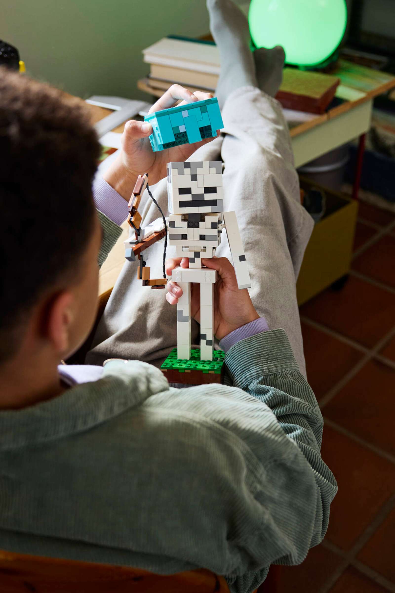 Child posing the LEGO Minecraft Skeleton figure