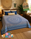 Blue and cream mandala print bed throw draped over a double bed in a bohemian bedroom setting