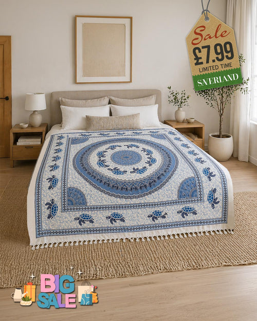 Blue and white sea turtle mandala tassel throw blanket draped over a bed in a bright boho bedroom