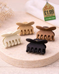 Four small butterfly claw clips in neutral colours