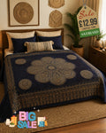Gold and navy blue mandala bed throw with intricate circular patterns and decorative border draped over a double bed