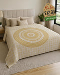 Golden mandala throw draped over a double bed, featuring intricate elephant and floral motifs in gold on a white background