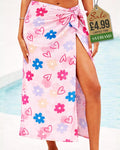 Pink beach sarong with hearts and daisy flowers print tied at the hip by the pool
