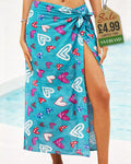 Teal beach sarong with assorted multicolour heart designs tied at the hip by the pool