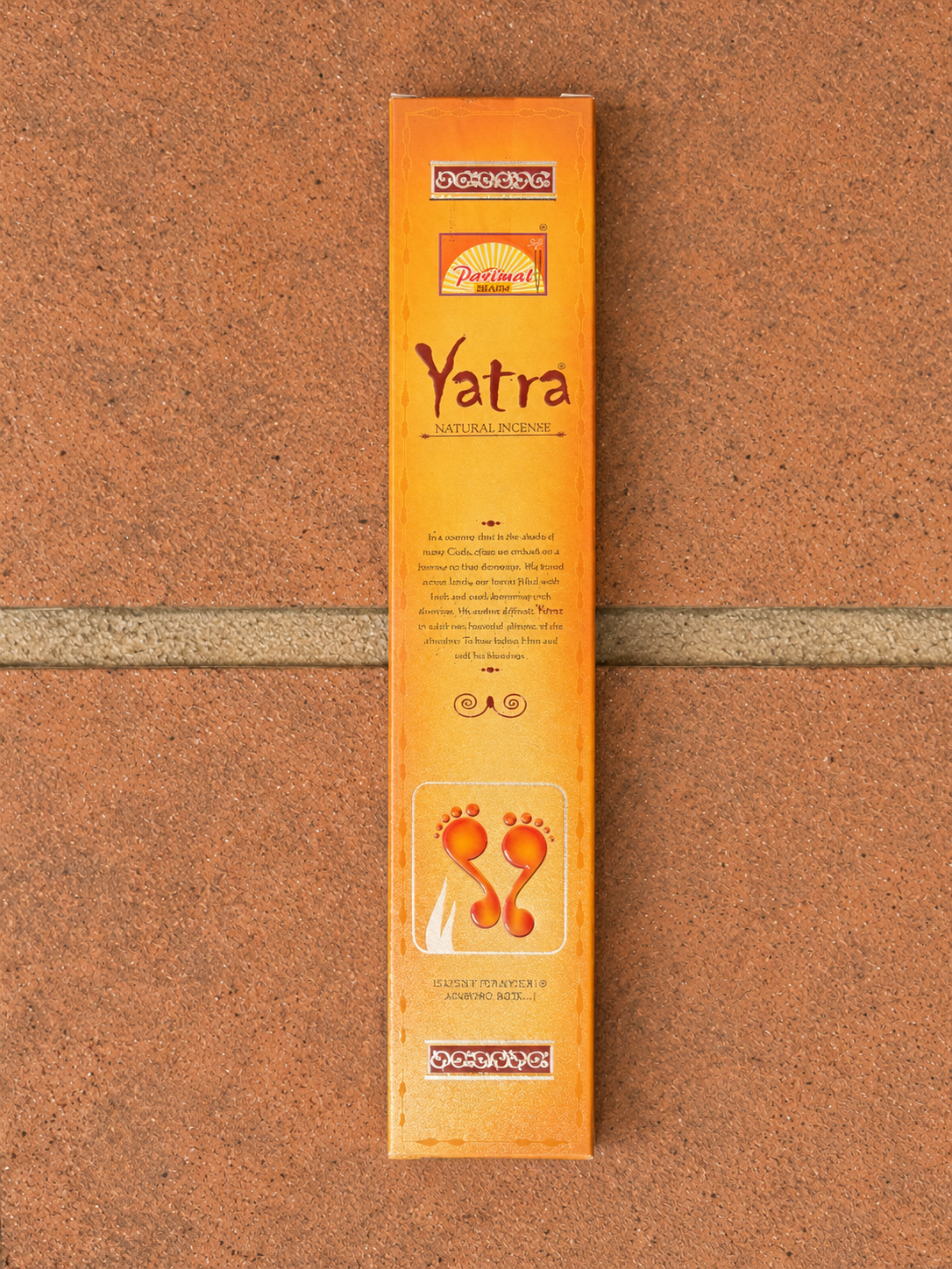 Yatra Natural Incense Sticks by Padma in orange packaging laid flat on terracotta tiles