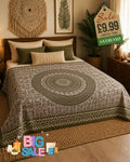 Olive green and cream mandala print bed throw draped over a double bed in a boho bedroom