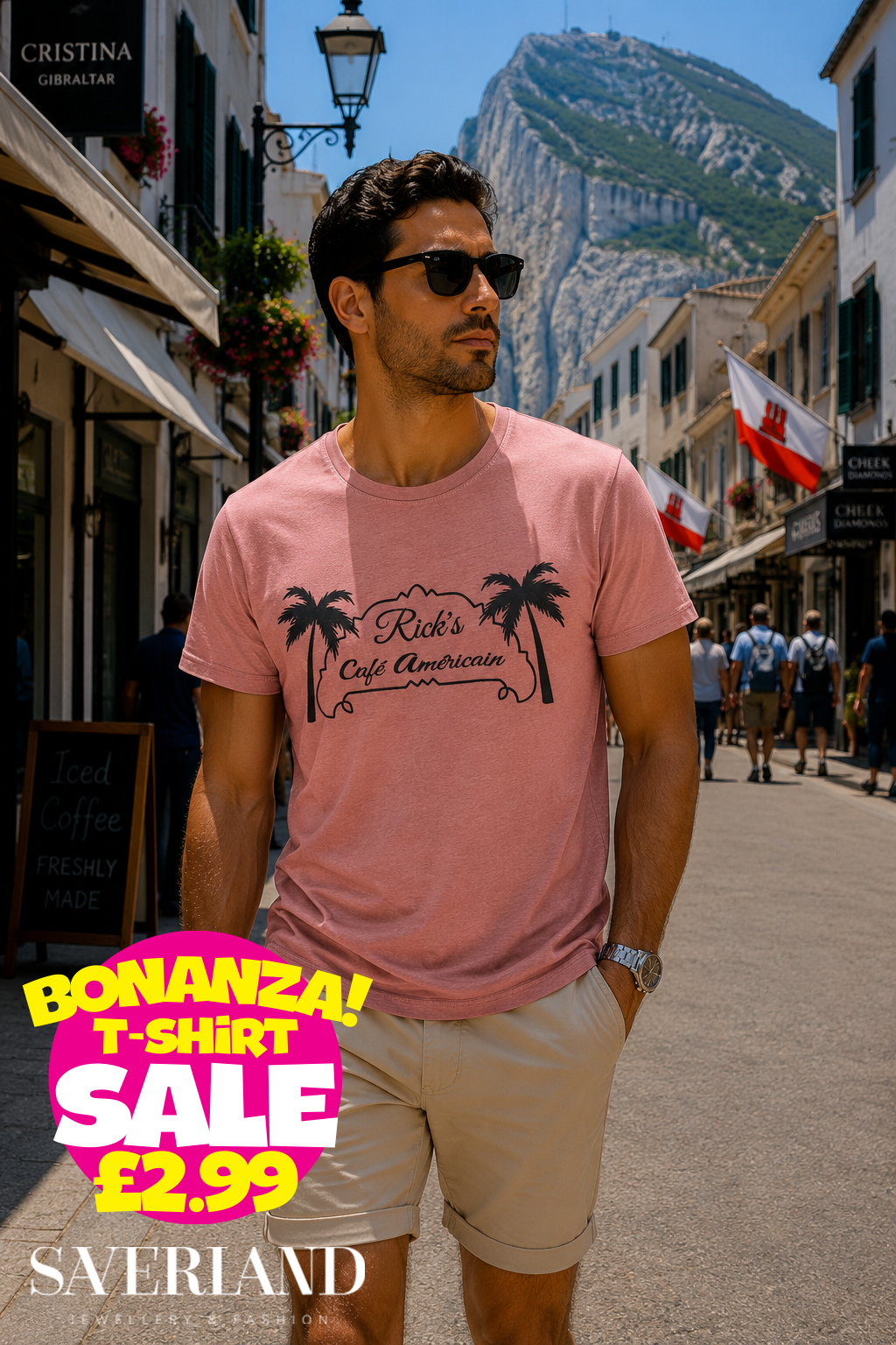 Man wearing a dusty pink Rick's Café Américain palm tree graphic t-shirt on a sunny Gibraltar street