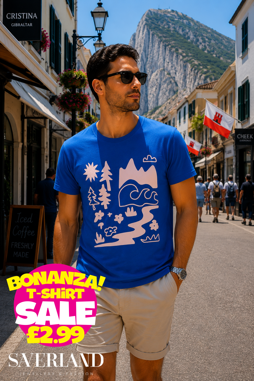 Man wearing a royal blue t-shirt with a blush pink nature scene graphic including mountains, trees, waves and flowers, photographed on Main Street Gibraltar