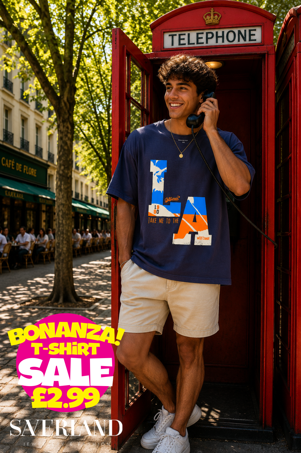 Man wearing a navy blue LA West Coast graphic t-shirt leaning against a red telephone box