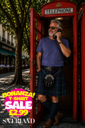 Man wearing a plain purple crew neck t-shirt standing in a red British telephone box