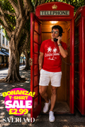 Red Catalina Island California palm tree graphic t-shirt worn by a man in a red telephone box