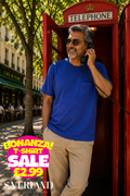 Man wearing a royal blue short-sleeve pocket t-shirt leaning against a red British telephone box